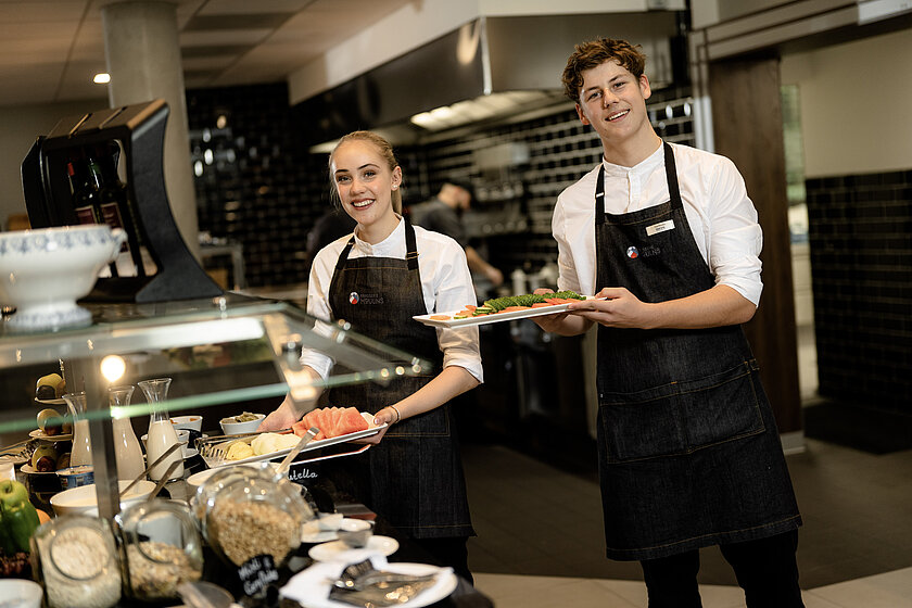 Zwei junge Dorint-Servicemitarbeiter beim Befüllen des Frühstücksbuffets